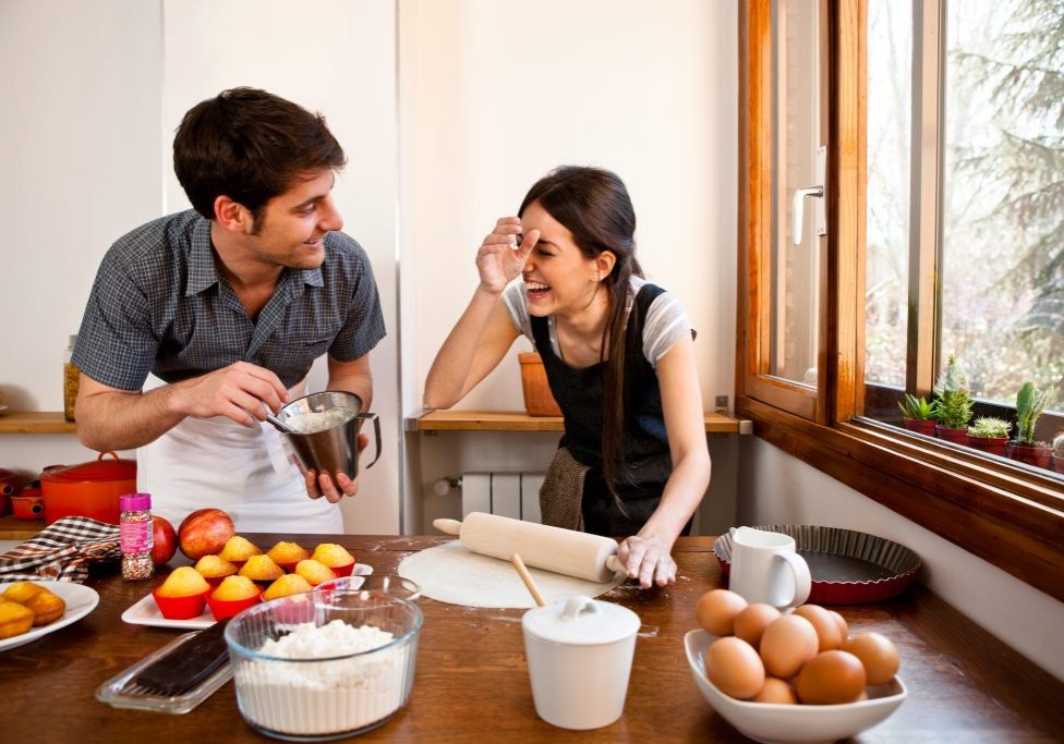 Pareja feliz cocinando en su cocina reformada
